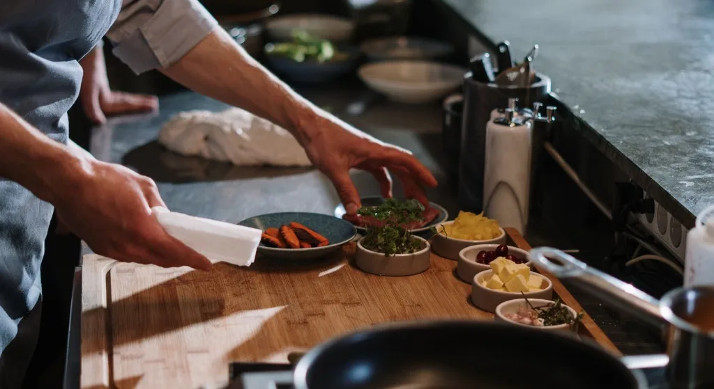 Chef organizing ingredients at a restaurant kitchen counter, ready for cooking